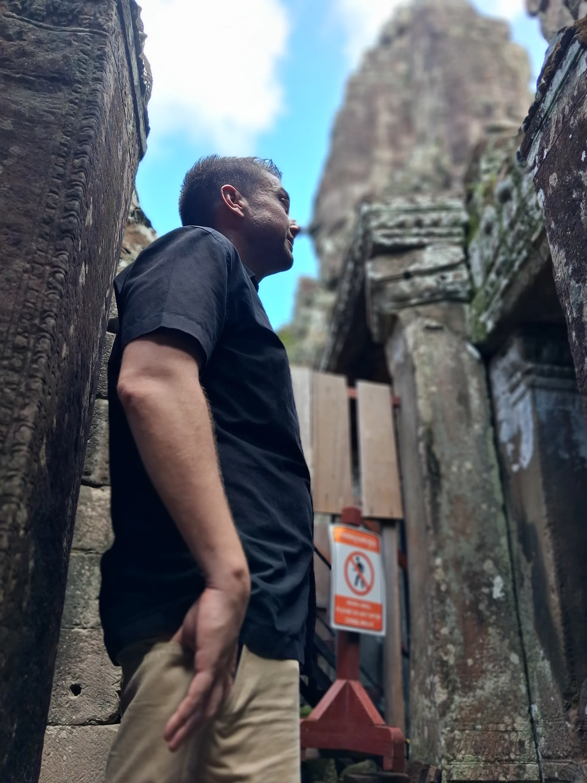 Mike Michelini looking up at ancient temple stonework near Siem Reap
