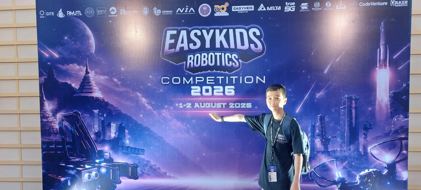 Miles standing at the EasyKids Robotics Competition 2026 backdrop