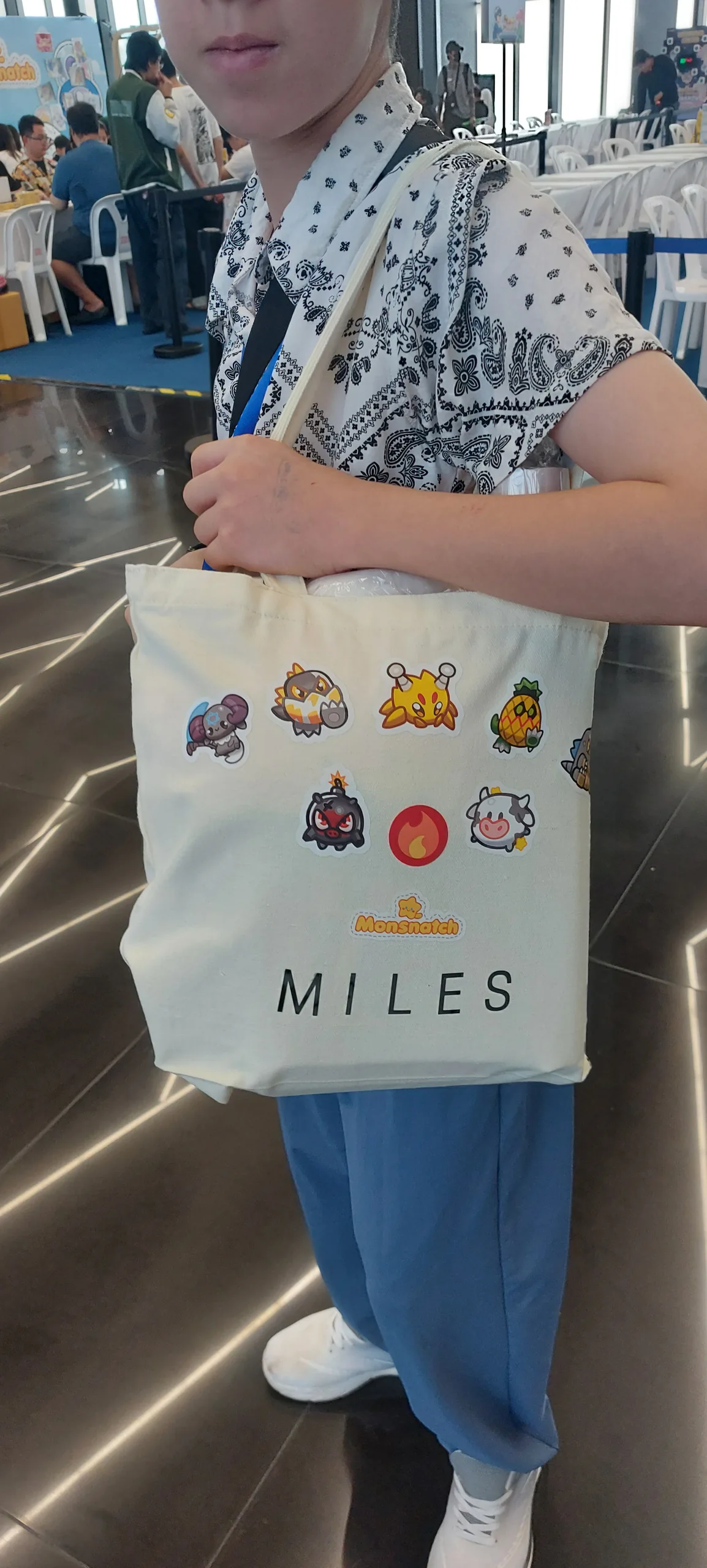 Miles holding his personalized Monsnatch tournament tote bag in Bangkok