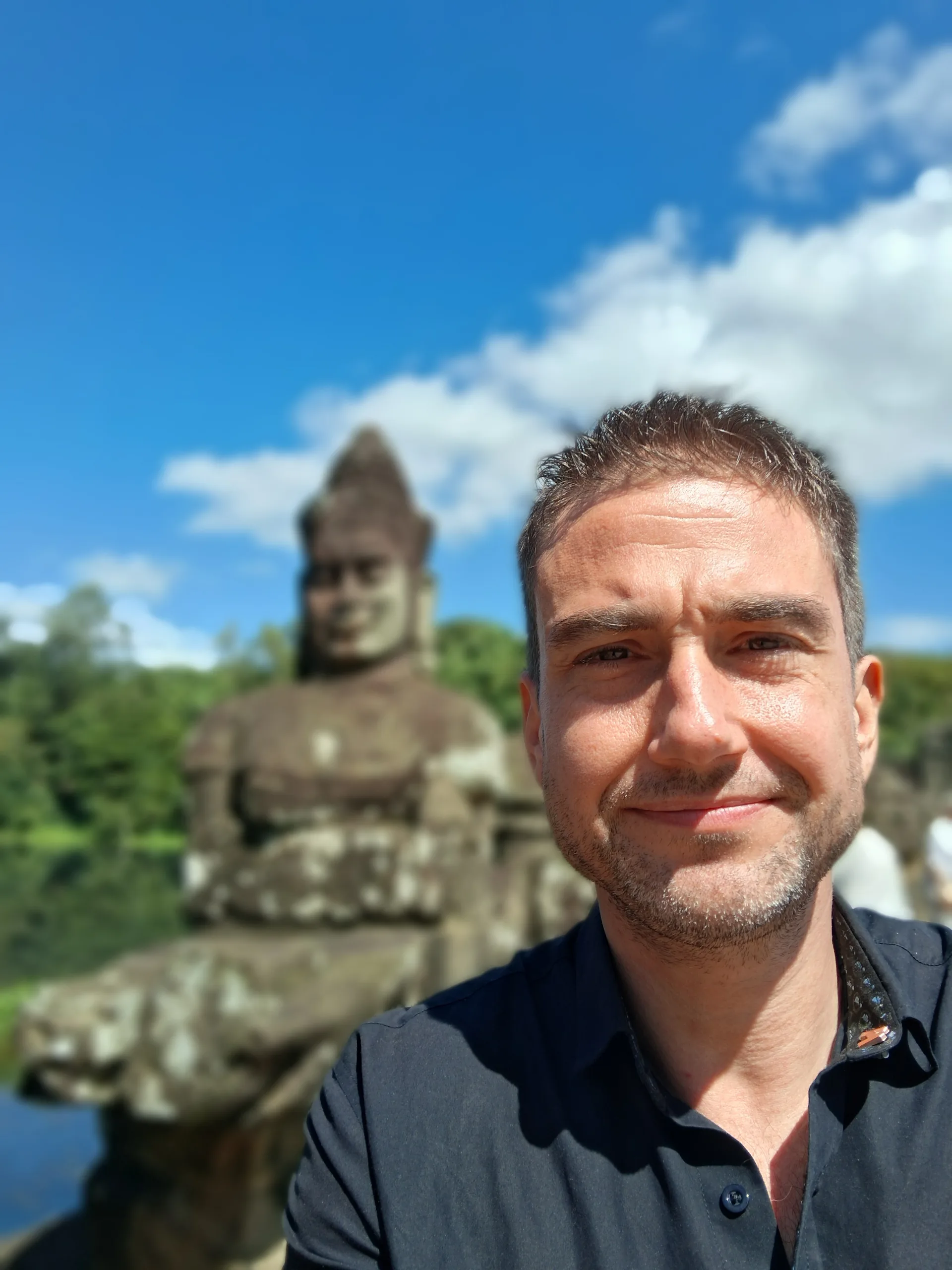 Mike Michelini at a historic stone sculpture near Siem Reap