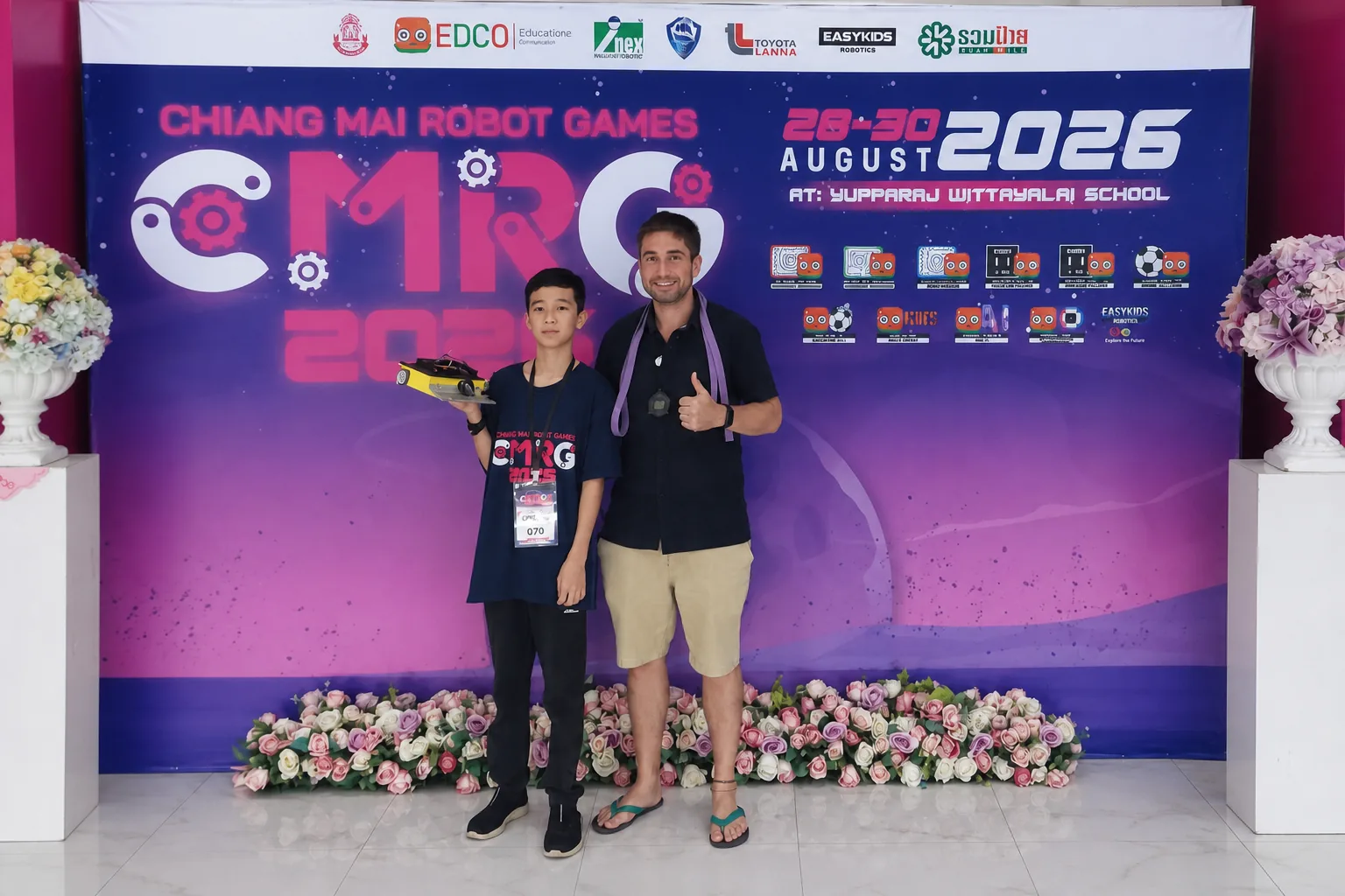 Mike Michelini and Miles at Chiang Mai Robot Games 2026 with Miles holding his sumo robot